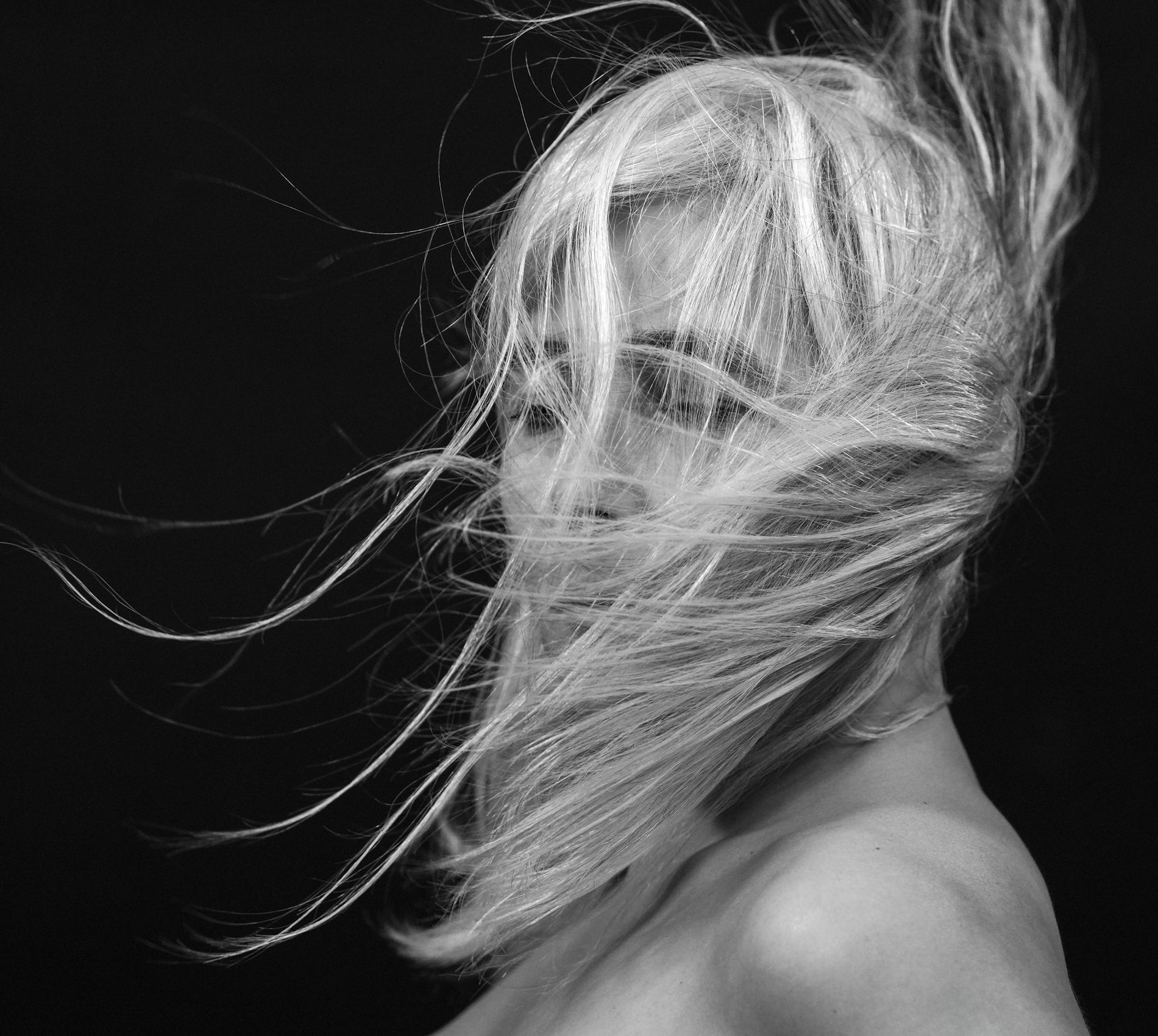 Woman in midlife looking at her hair in a mirror